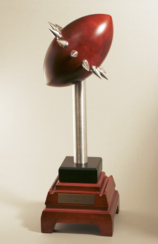 Arisiabowl trophy:  A red football ~10" x 6" with a ring of a dozen spikes around the middle, atop an aluminum pillar with a red base shaped somewhat like an obelisk.