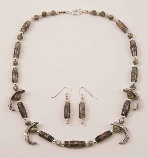 Necklace with grey and earthtone lampworked beads and foldformed silver ornaments