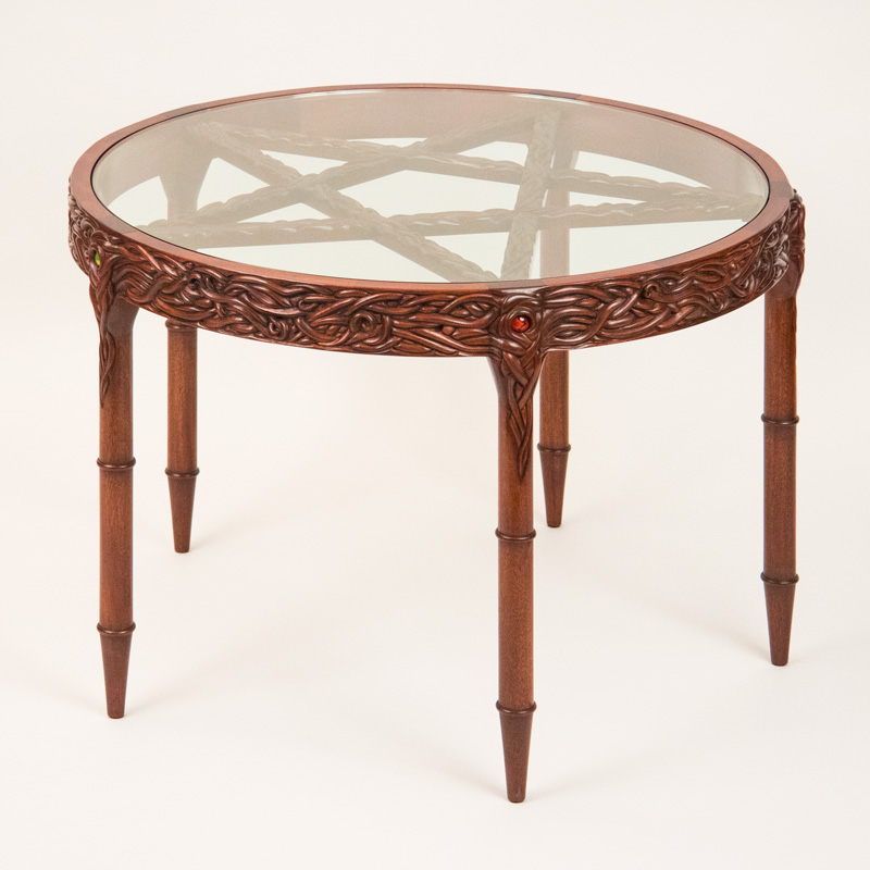Pentacle Table - Round with glass top, tendril carved rim, turned and carved legs, and carved pentagram under the glass. One inch glass marbles are embedded in the top of each leg.